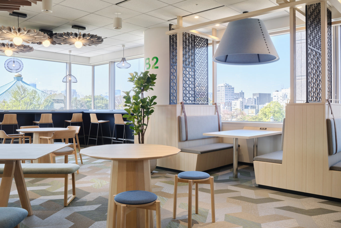 カフェテリア。大きな窓とテーブル席のある共有空間